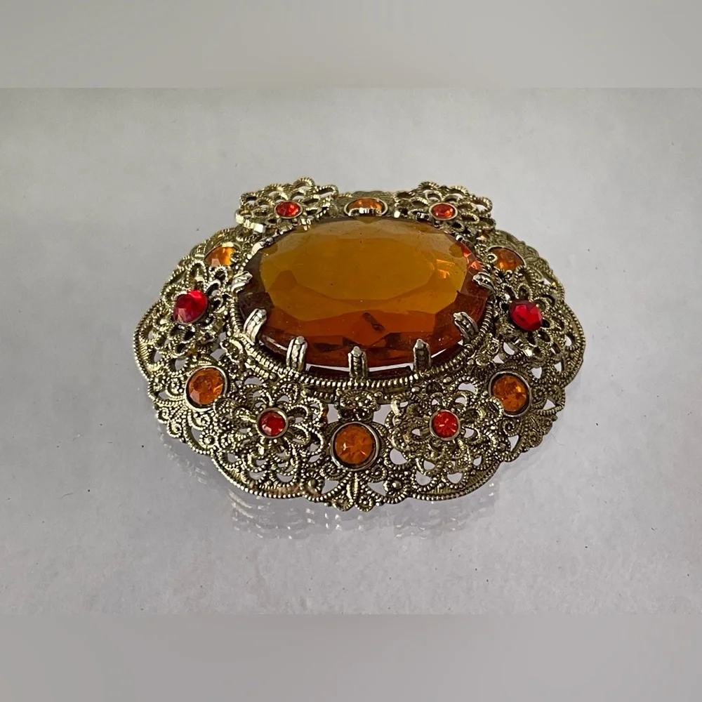 Vintage West Germany brooch featuring a large amber topaz glass filigree gold